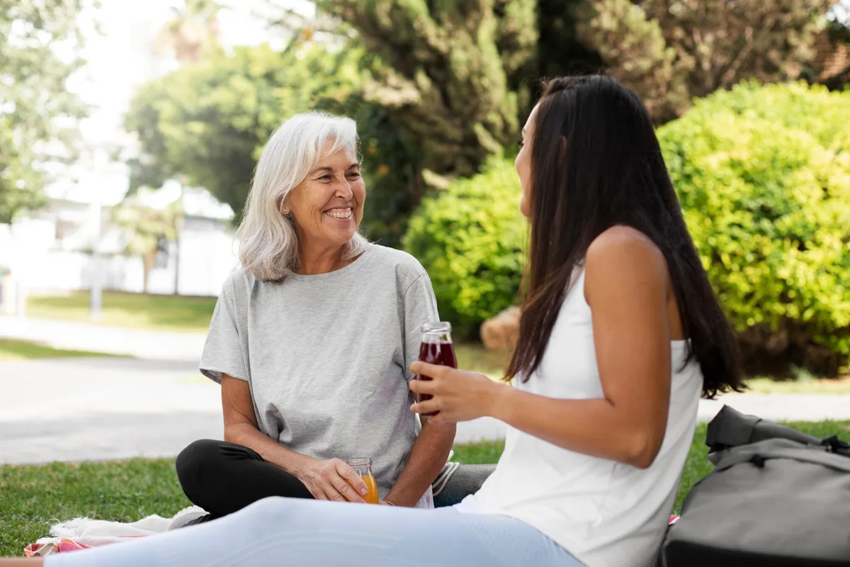 An older woman and a younger woman talking together outdoors